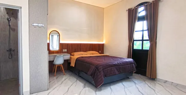 Kasur queen size kamar kos AVILITA House dengan linen bersih dan headboard kayu