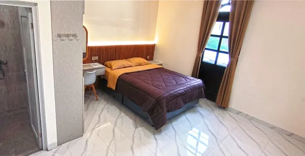 Sudut kamar studio AVILITA House dengan meja kerja, kursi ergonomis, dan WiFi 400 Mbps
